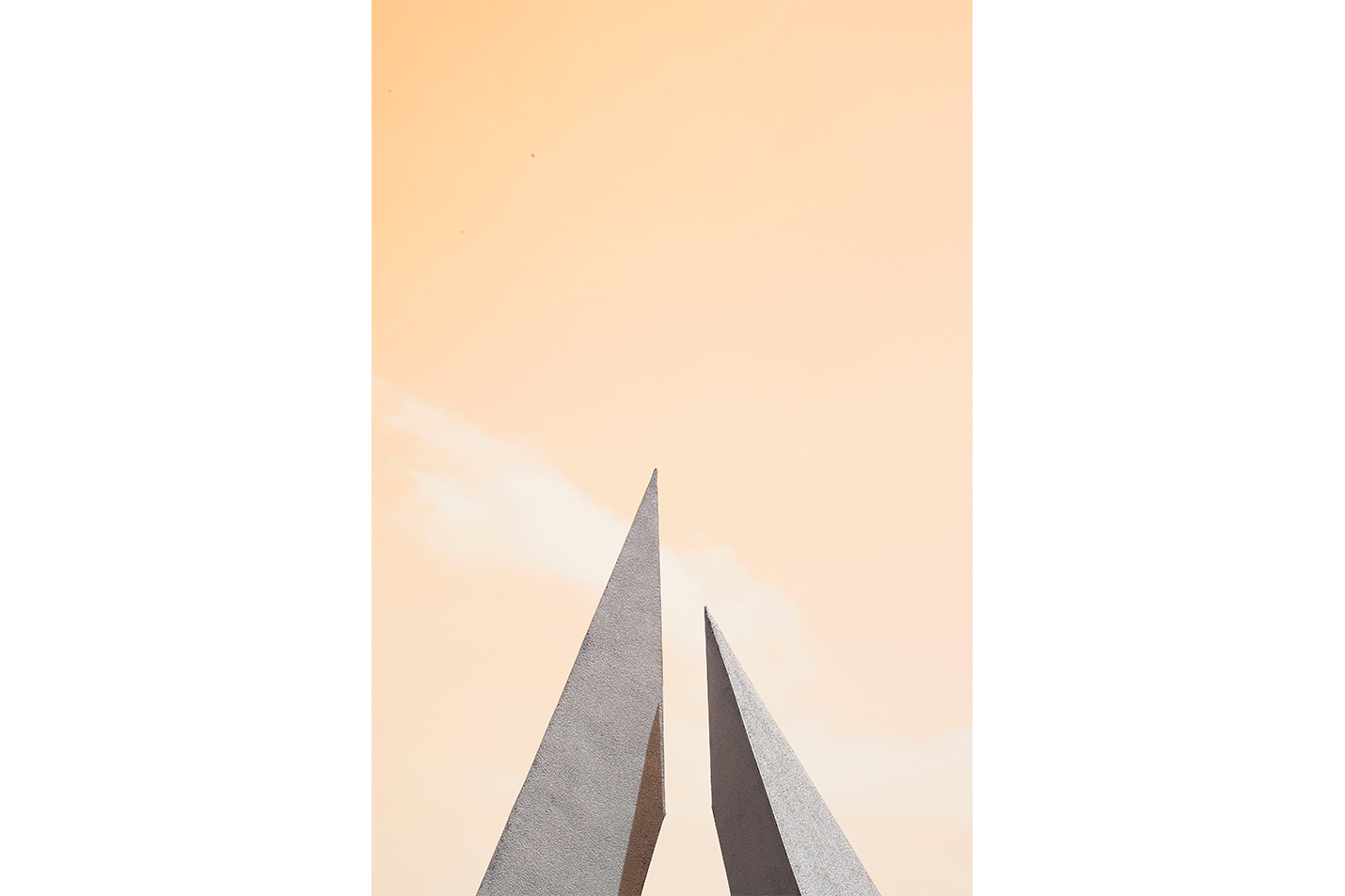 minimalist architectural photo of two sharp triangular structures against a warm pastel sky, abstract, art, kanvas tablo